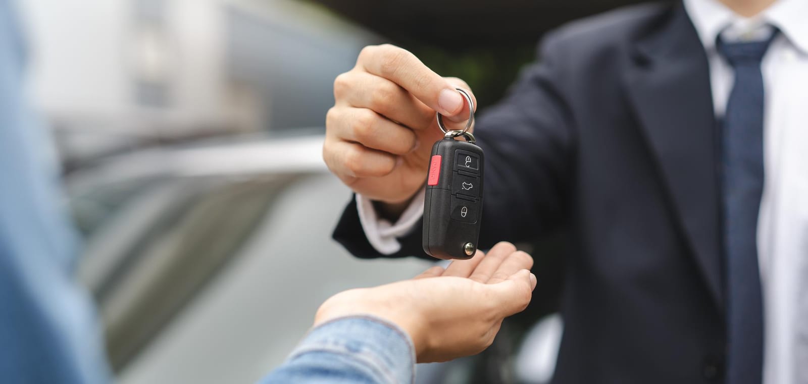 Representante comercial entrega a chave de um veículo a um cliente